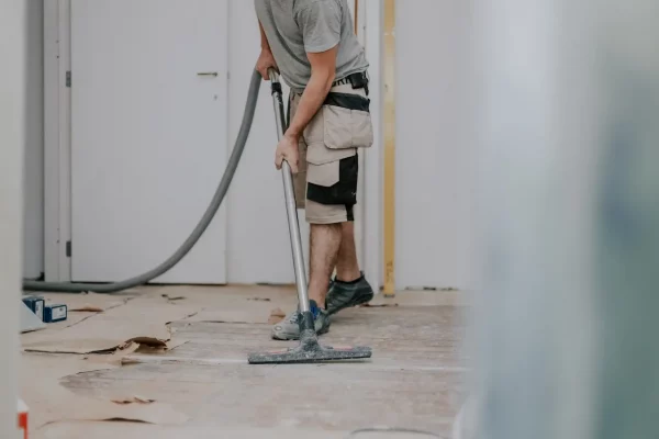 a-young-man-vacuums-the-floor-with-a-construction-2026-03-18-04-22-50-utc