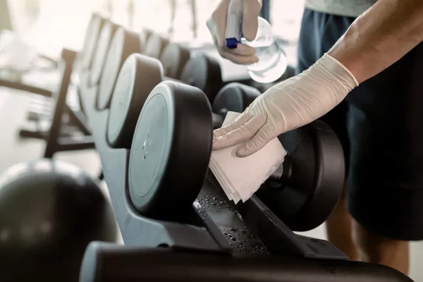 close-up-of-athletic-man-cleaning-dumbbells-with-d-2026-03-16-03-29-07-utc